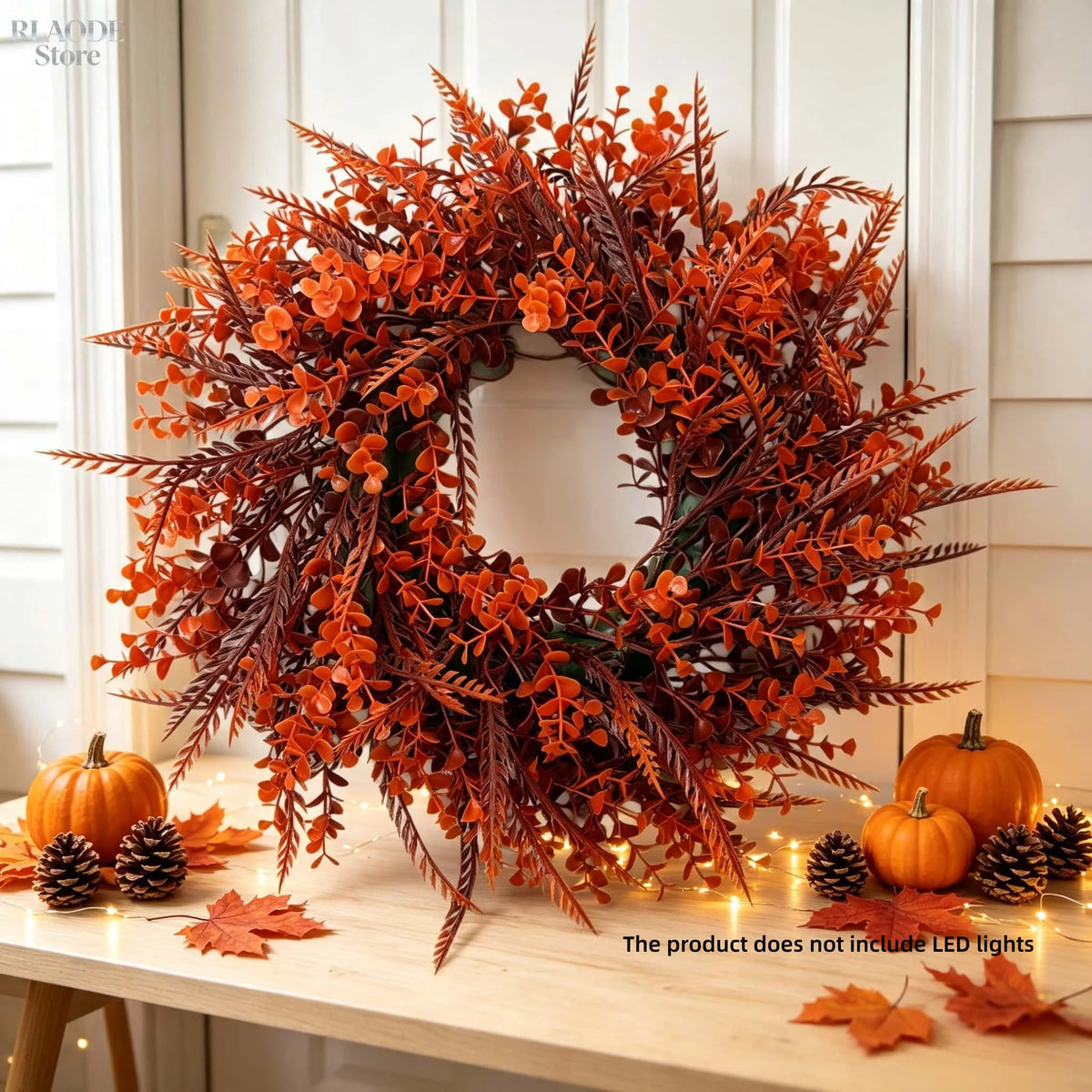 An artificial eucalyptus wreath made of reddish-orange foliage and pinecones for autumn decor