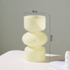 A handcrafted glass flower vase in pale yellow, featuring a two-tiered, rounded design.