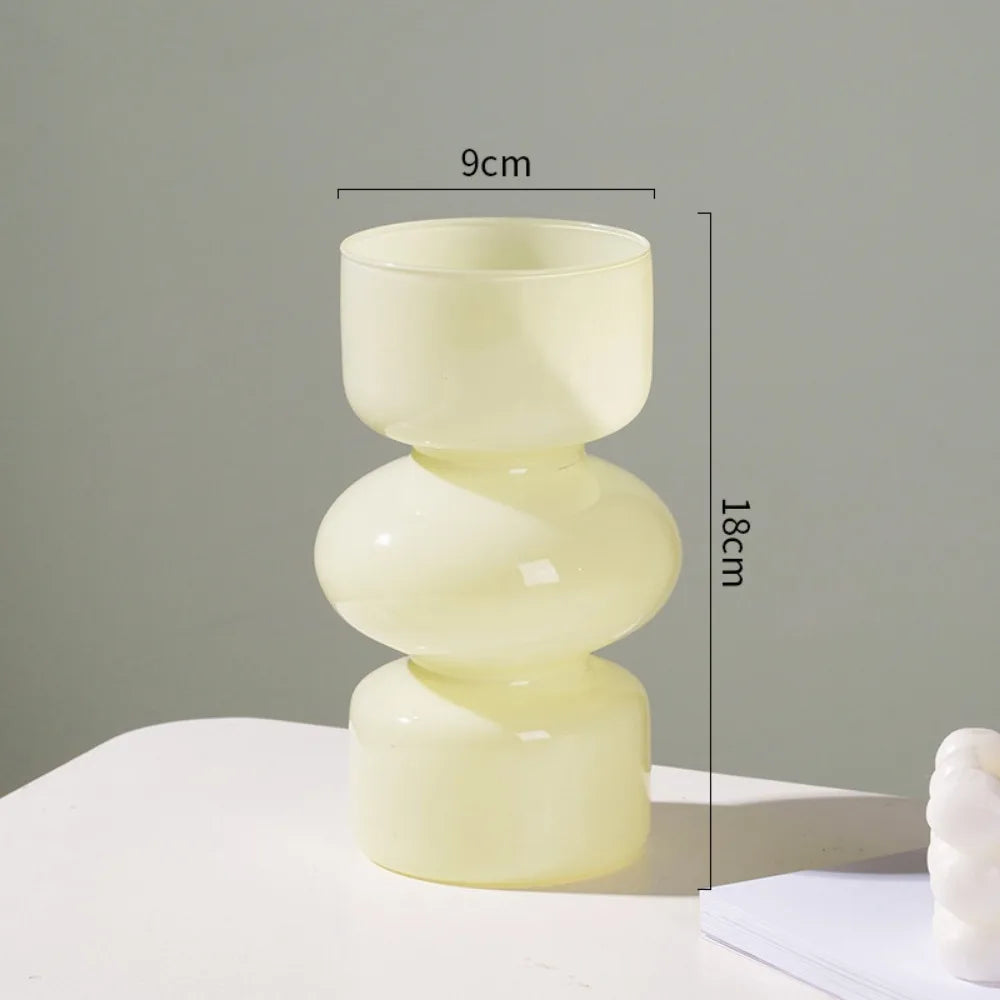 A handcrafted glass flower vase in pale yellow, featuring a two-tiered, rounded design.