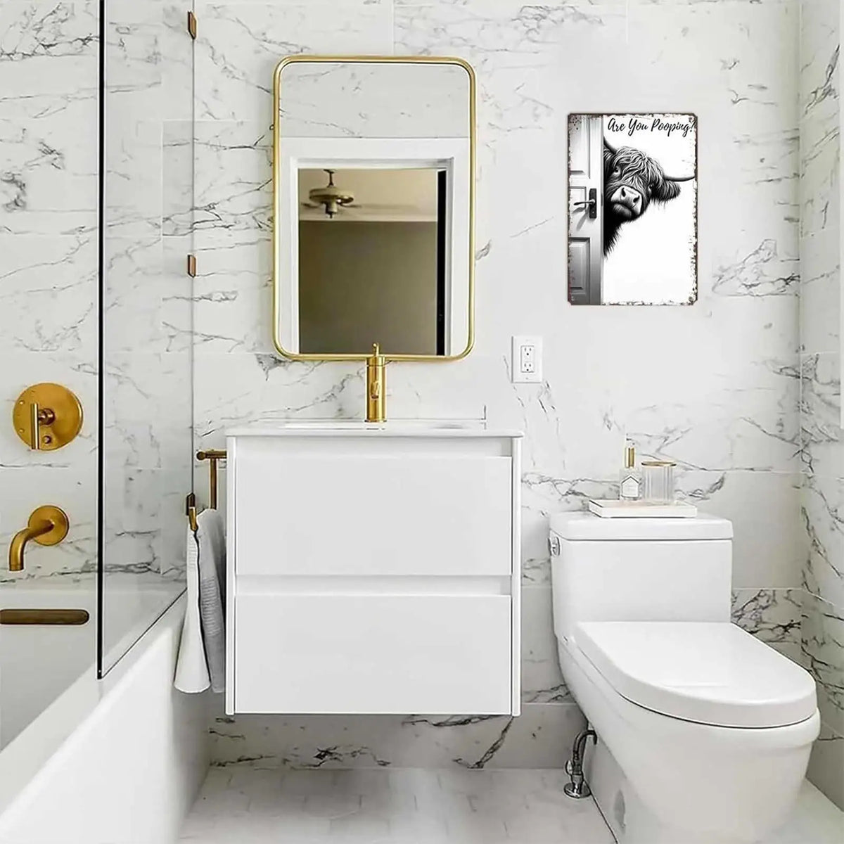 Un meuble-lavabo de salle de bain avec miroir, lavabo et toilette, décoré d'art mural vintage de vaches.