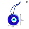Blue glass evil eye amulet pendant with a white pupil and gold string.