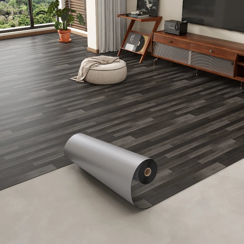 Roll of 3D textured wood grain self-adhesive flooring film displayed on a light floor.