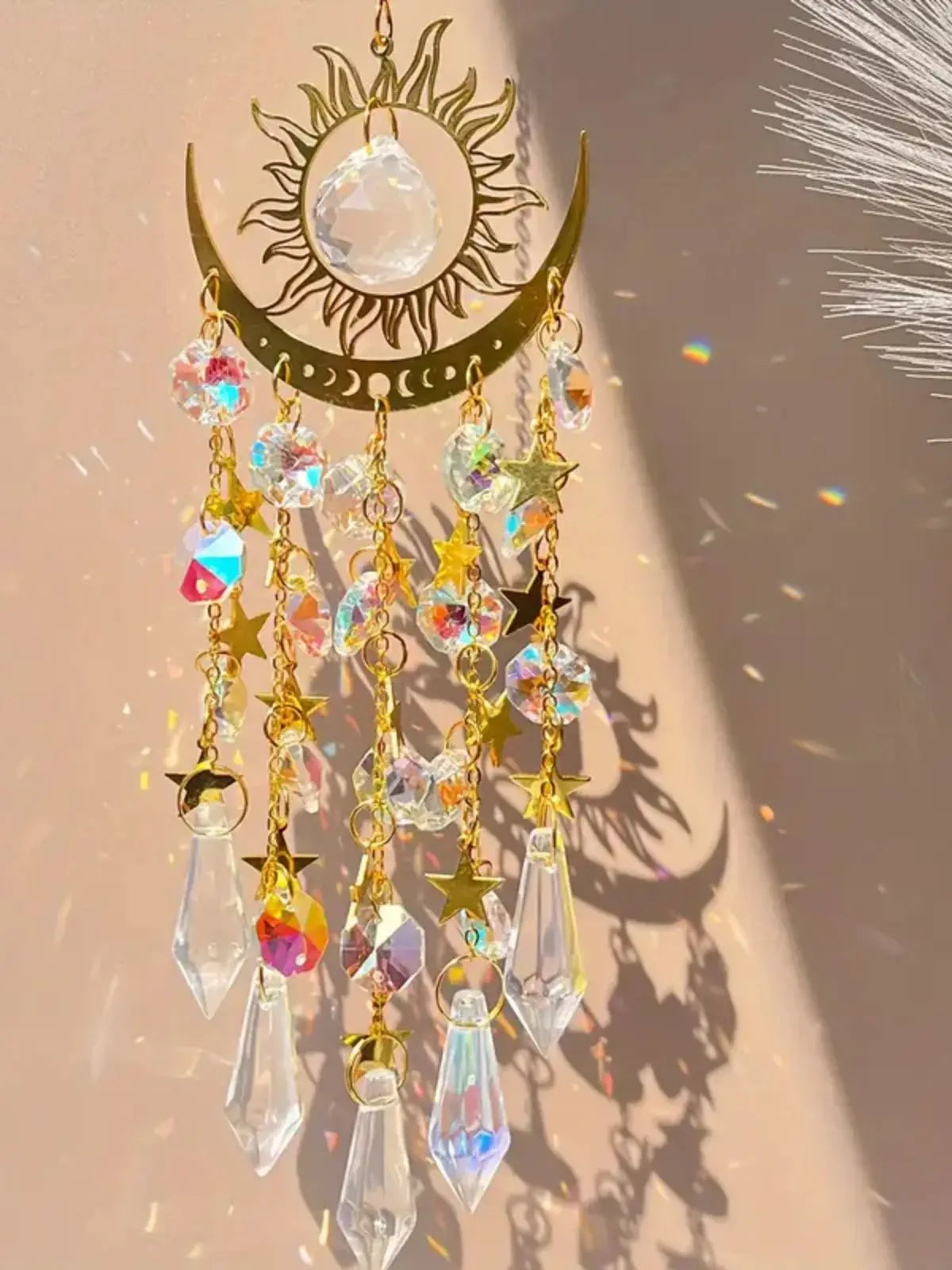 Gold star moon wind chime featuring a crescent moon and sun with dangling clear and iridescent crystals