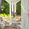 Gray fabric curtains with wooden bead tiebacks framing a garden view and antique furniture.