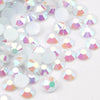 A close-up view of round flatback resin rhinestones in various iridescent colors scattered on a white surface.