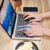 A person uses reusable blue wheat straw chopsticks to pick up food while using a laptop.