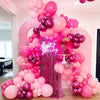 Grand arche de ballons rose et or rose dans un cadre festif.