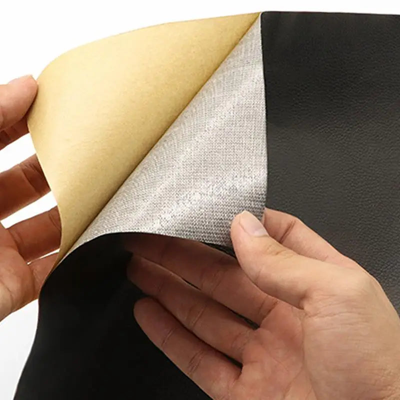 Una mano está quitando un parche de reparación de cuero PU autoadhesivo, mostrando el material en capas.