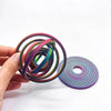 A hand holds a stack of colorful, thin rings or bands, demonstrating a rotating ball spinner fidget toy.