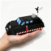 A black 3D printed model of a Tornado intercept vehicle with white and red hazard stripes, displayed in a hand.
