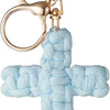 A light blue woven cross keychain with a gold-toned metal ring and clasp.