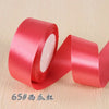 A roll of bright red silk satin ribbon used for gift wrapping and craft projects.
