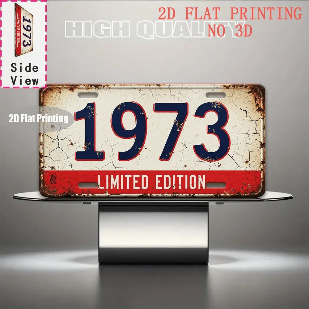 A distressed metal tin sign featuring the year 1973 in red and blue lettering, presented on a silver stand.