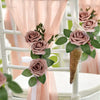 Artificial real touch foam roses in dusty rose and green foliage decorating a white chair