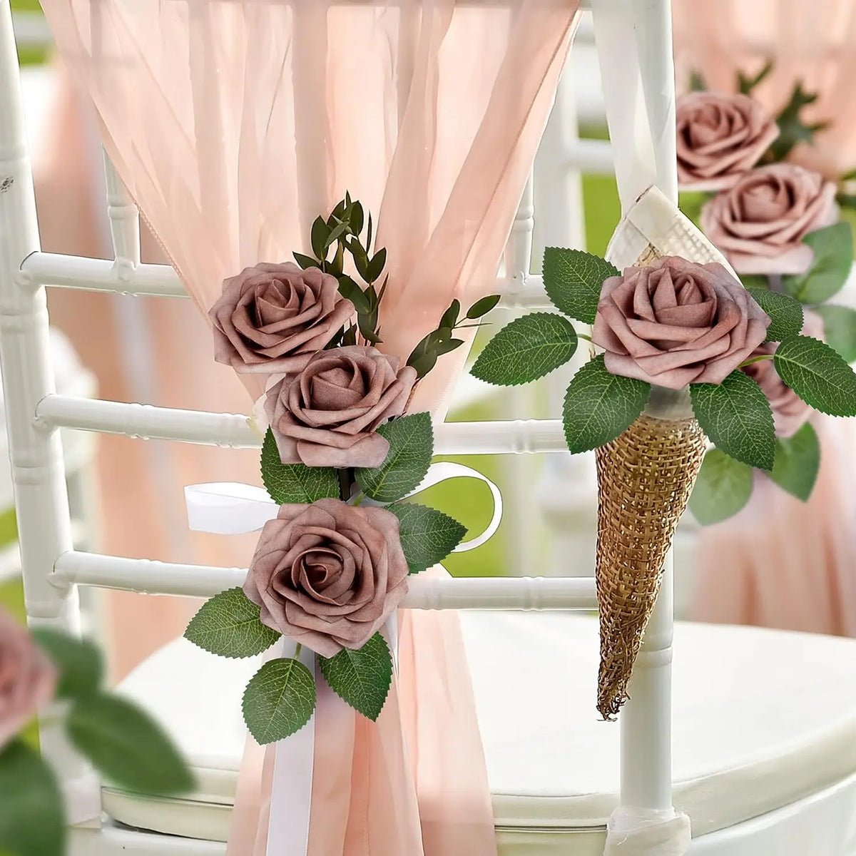 Artificial real touch foam roses in dusty rose and green foliage decorating a white chair