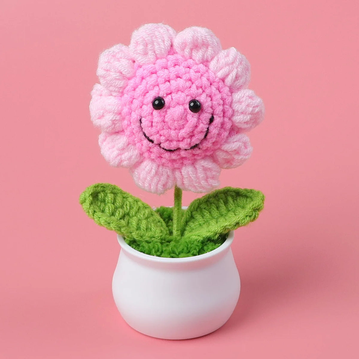 Hand woven pink crochet flower potted in a white ceramic pot