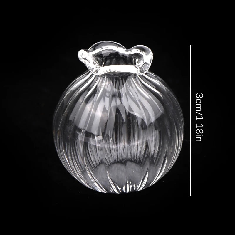 A clear glass vase shaped like a bottle with a flared rim, shown against a black background.