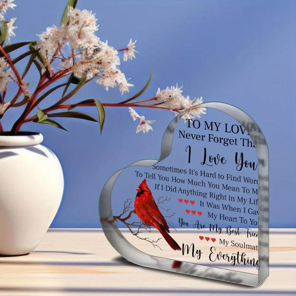 A heart-shaped acrylic plaque with a bird design and a love message engraved on it.
