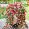 A dense arrangement of pink and red artificial flowers used for outdoor decor.