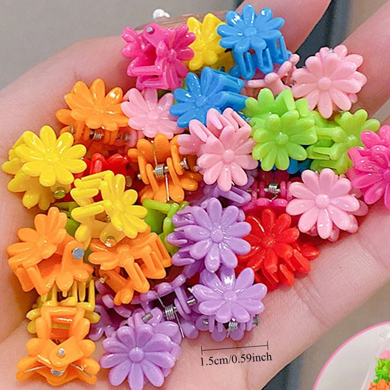 A collection of colorful flower and star hair claw clips for kids displayed on a hand.