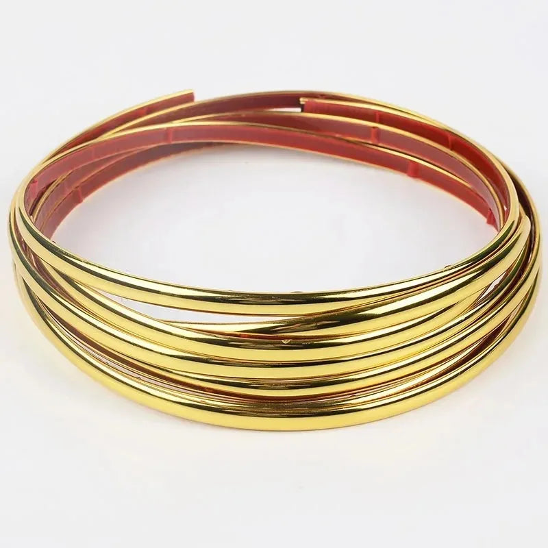 Gold and red self-adhesive PVC wall trim tape coiled on a white background.