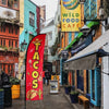 A red feather flag advertising Mexican food tacos for restaurants and markets.