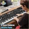 A young boy plays a 61-key electric piano with a microphone on a wooden desk.