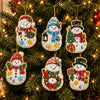 A set of Christmas diamond art ornaments featuring Santa, a snowman, and reindeer pendants hanging on a green Christmas tree.