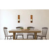 A rustic wooden dining table set with matching wooden candle holders on a white wall.