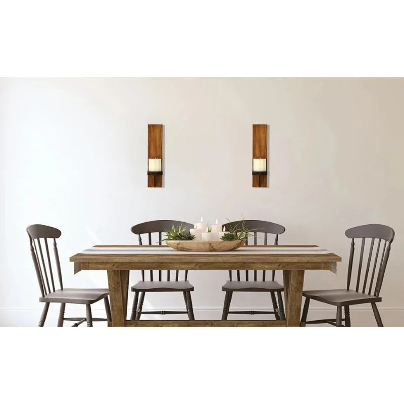 A rustic wooden dining table set with matching wooden candle holders on a white wall.