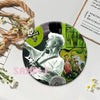 A round button pin featuring a black and white photo of a musician playing a guitar against a green background.