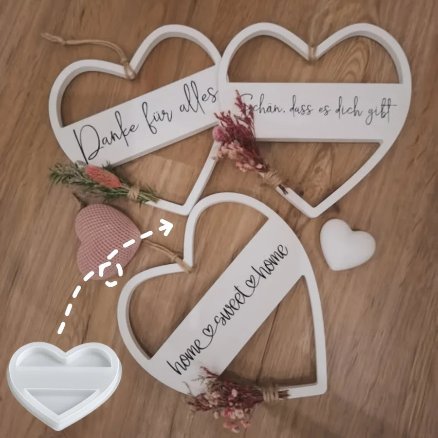 Eine Sammlung weißer, herzförmiger Holzschilder mit handgeschriebenen Botschaften und getrockneten Blumen.