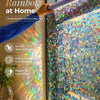Hand applying a 3D iridescent static cling film to a window, showing a colorful, holographic effect.