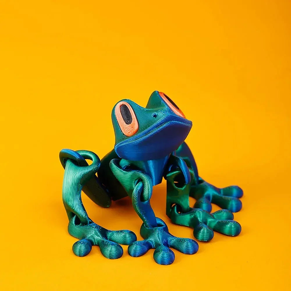 A vibrant teal tree frog ornament with large eyes is displayed against a solid orange background.