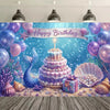 A vibrant blue mermaid tail birthday backdrop featuring a tiered purple cake surrounded by iridescent bubbles and sea flora.
