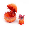 An orange 3D printed dragon egg is cracked open, revealing a small, pink dragon toy inside.