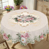 Vintage floral tablecloth featuring a delicate pink and green rose and daisy print on a round table.