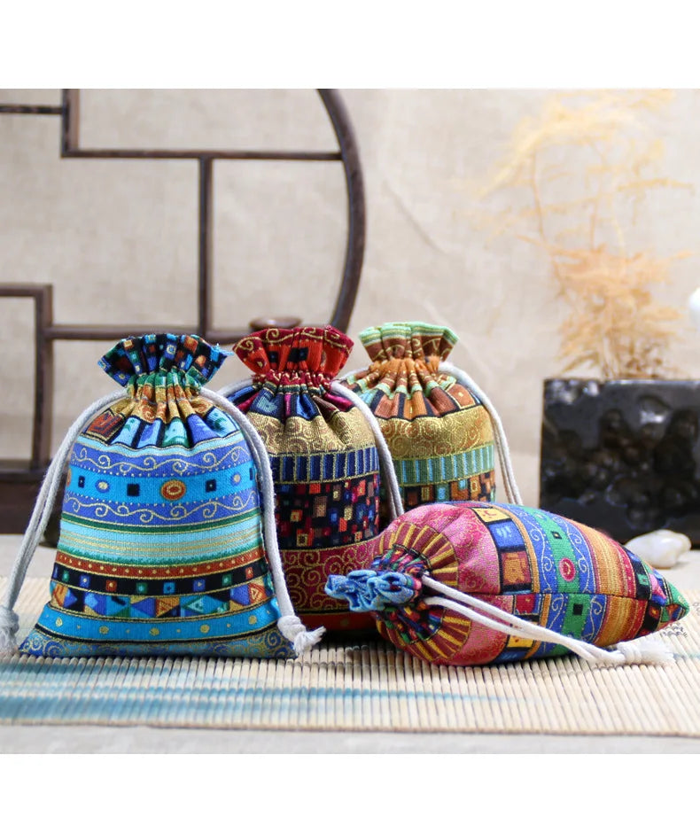 A set of ten vintage cotton drawstring gift pouches in various colorful patterns and textures.