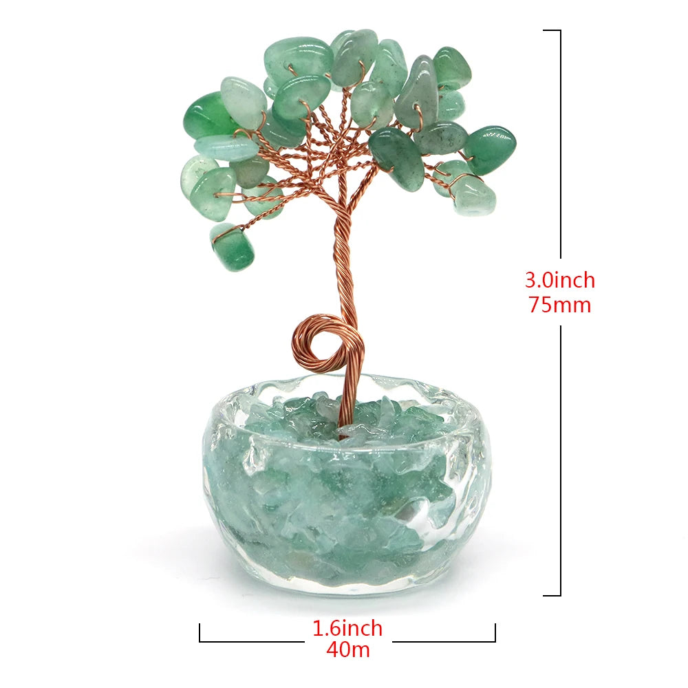 A crystal healing gemstone bonsai featuring green jade-like leaves growing from a wooden branch in a clear glass bowl.