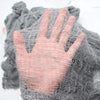 A hand is visible through a mesh of black creepy gauze cloth used for Halloween decor.