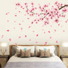 Pink peach blossom branch wall decals decorating a bedroom wall above a bed