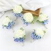 A set of six silk rose boutonnières featuring white roses and dusty blue hydrangeas on thin stems.