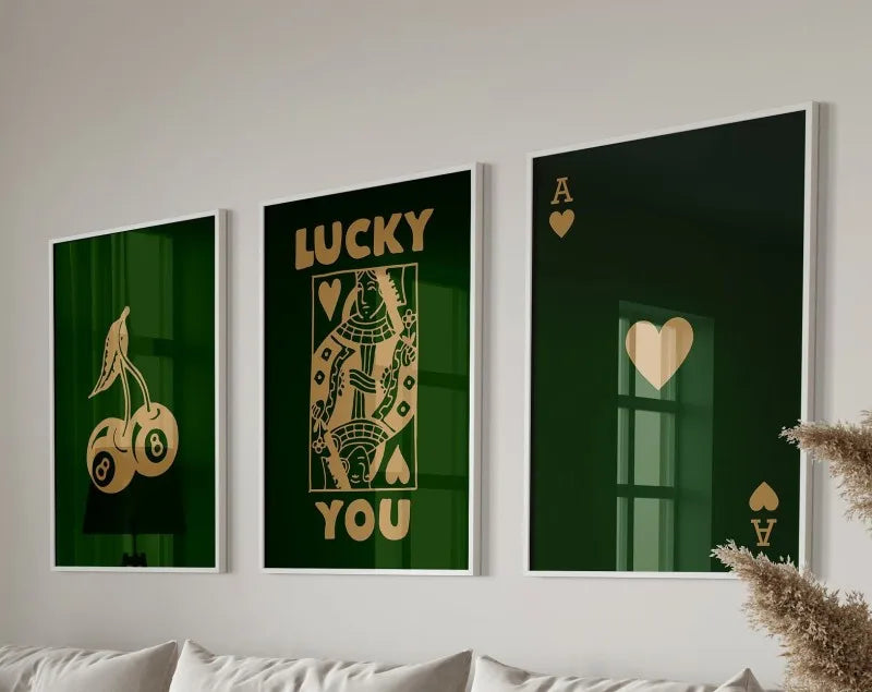 Three framed art prints featuring the text LUCKY YOU in gold lettering on a dark green background