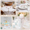 Mini baptism rosary favors with cross in assorted styles displayed on a white lace cloth and floral arrangements.