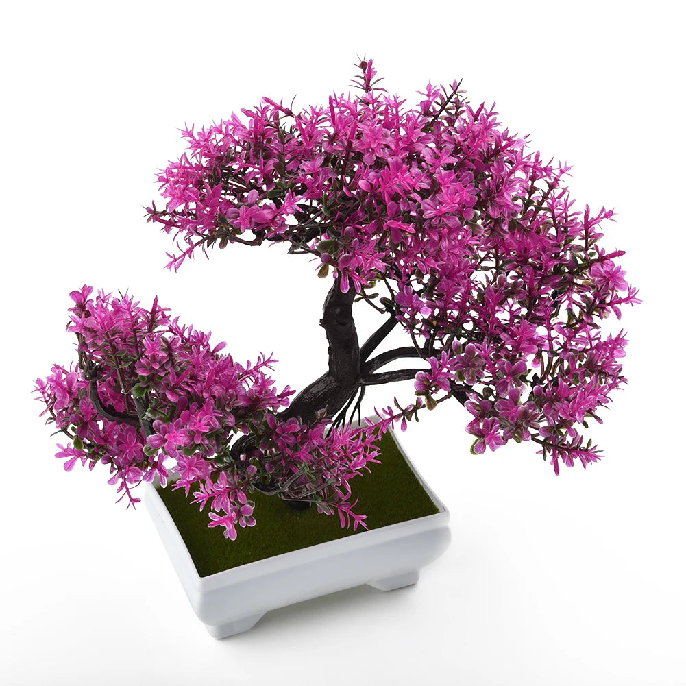 Un faux bonsaï réaliste avec des feuilles magenta vibrantes planté dans un pot blanc carré.