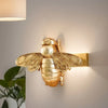 Handgefertigte goldene Bienenwandskulptur, montiert an einer weißen Wand.
