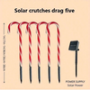 Five red and white candy cane shaped solar lights with power supply.