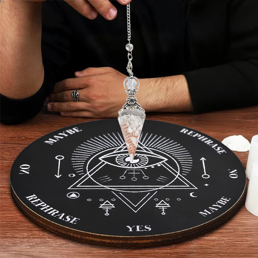 A crystal pendulum is displayed on a wooden divination board with various symbols and text.