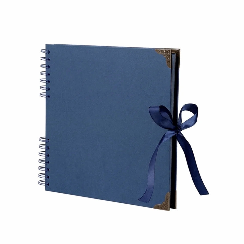 Carnet photo lay-flat bleu foncé avec accent or et ruban bleu marine sur la couverture.