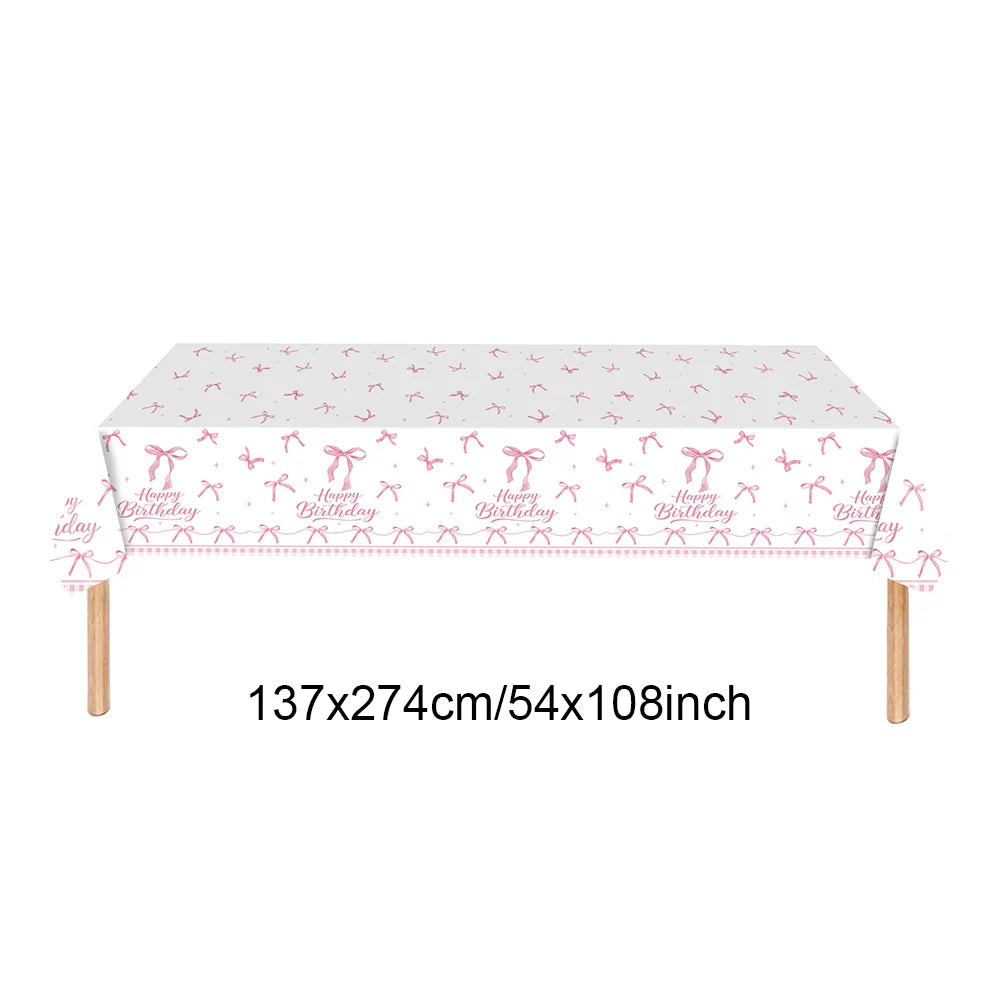 A rectangular pink bow themed birthday party supplies set displayed on a wooden frame.